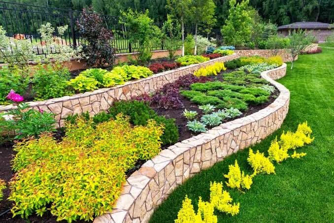 Tiered garden with curved stone retaining walls and colourful shrub planting